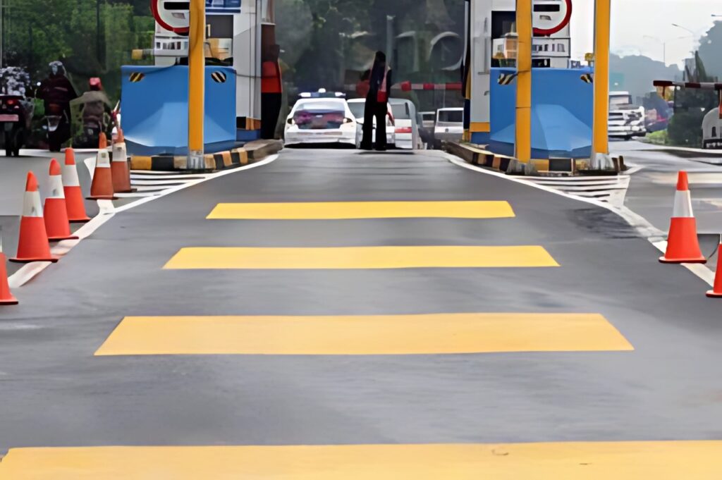 Pengecatan marka jalan kuning di pintu masuk tol oleh tim Eltama Coating menggunakan cat khusus jalan raya